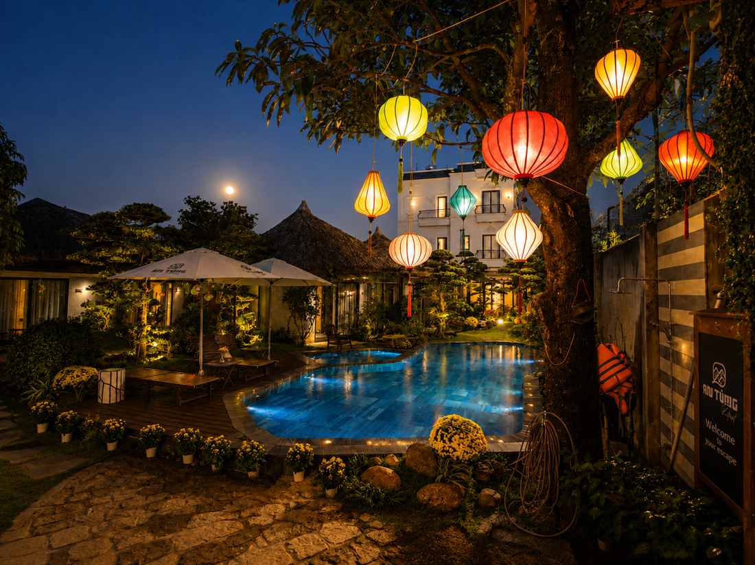Lantern-lit pool and garden at An Tùng Retreat in the evening
